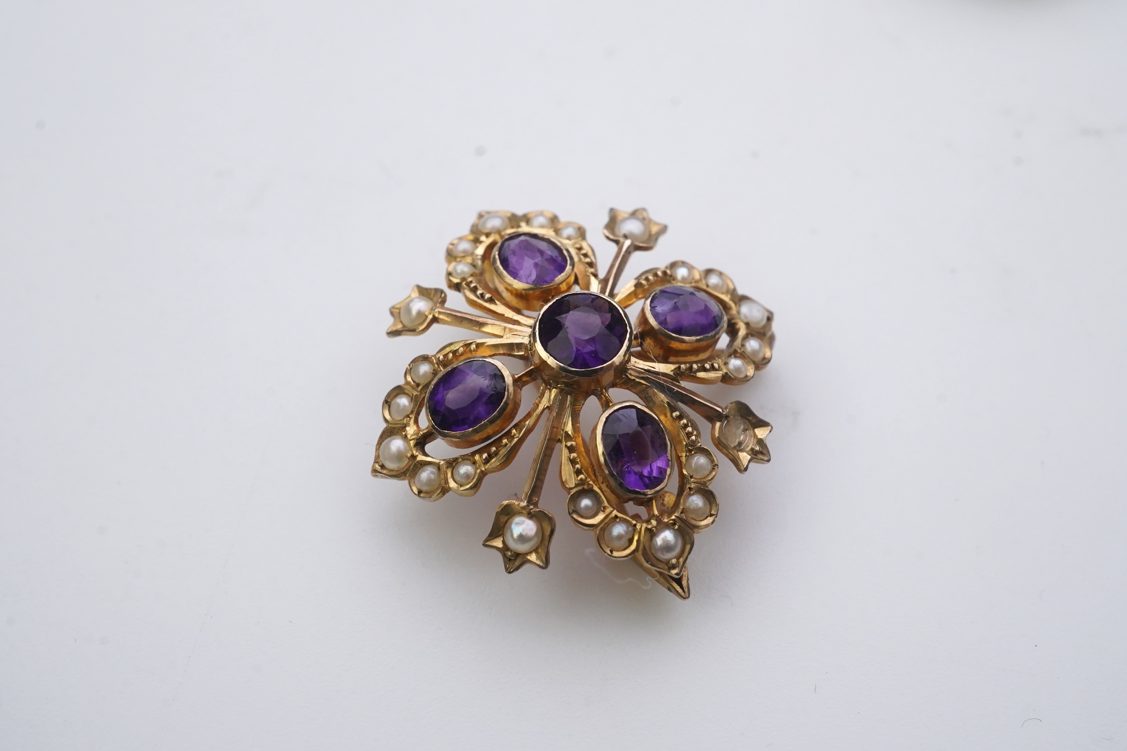 A Georgian mourning brooch, early 19th century, two Edwardian pendants, early 20th century